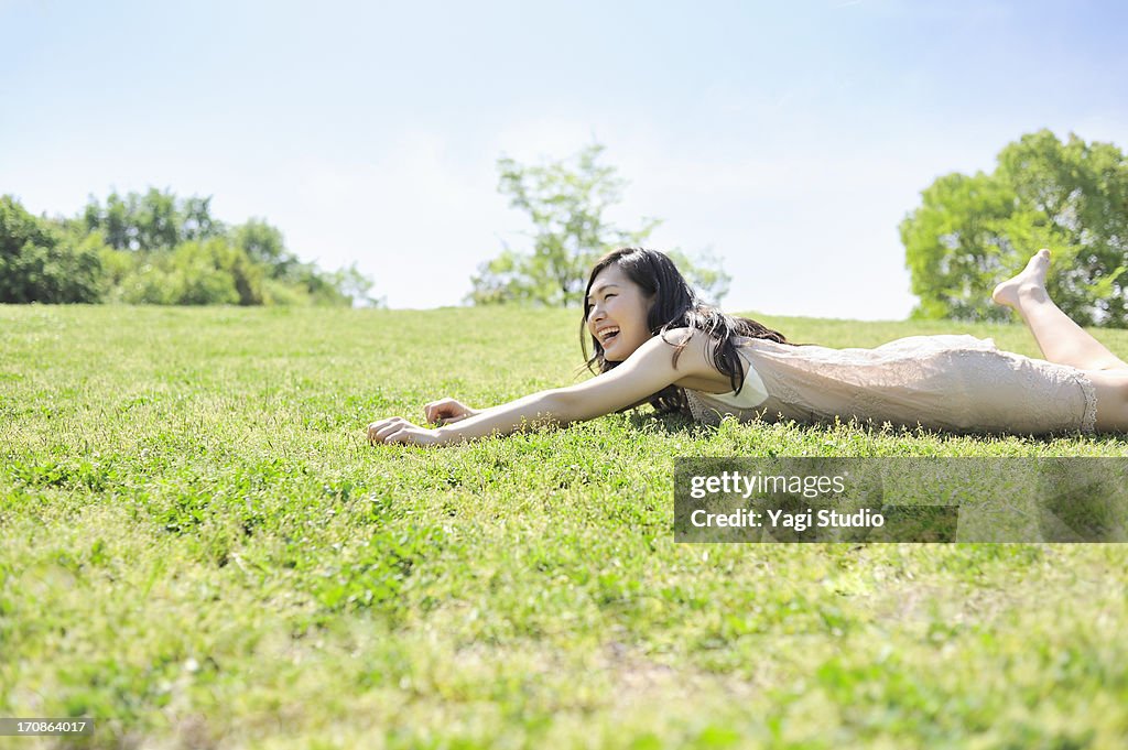 Woman laying down in nature, smiling