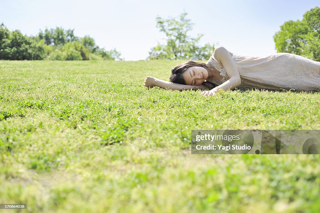 Woman laying down in nature, eyes closed