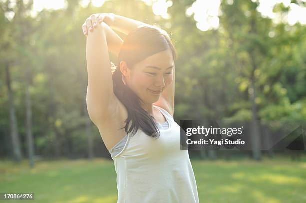 woman doing stretch exercises in nature - stretching ストックフォトと画像
