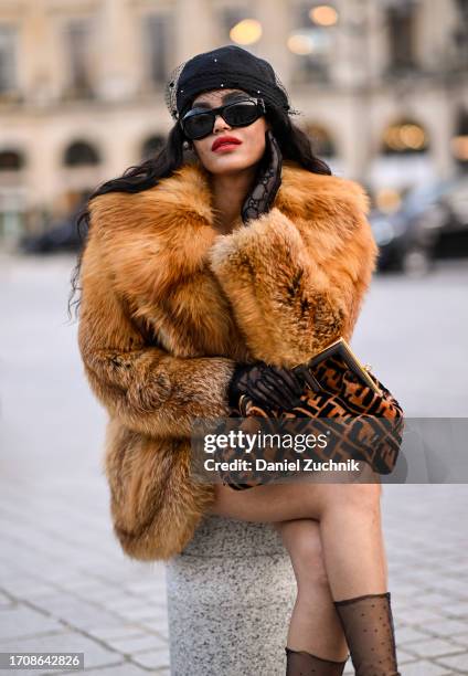 Leila Depina is seen wearing a vintage fur coat, Fendi bag, Gucci sheer gloves and a black cap with black sunglasses during the Womenswear...