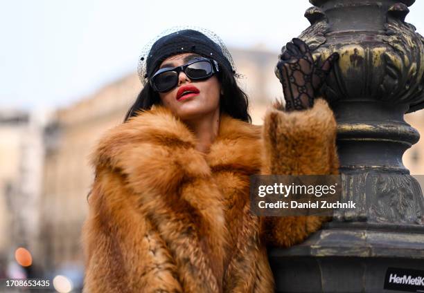 Leila Depina is seen wearing a vintage fur coat, Gucci sheer gloves and a black cap with black sunglasses during the Womenswear Spring/Summer 2024 as...