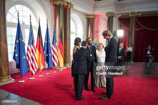 In this handout photo provided by the German Government Press Office , U.S. President Barack Obama and First Lady Michelle Obama stand alongside...