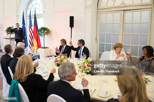 In this handout photo provided by the German Government Press Office , U.S. President Barack Obama raises a toast as NBA basketball player Dirk...