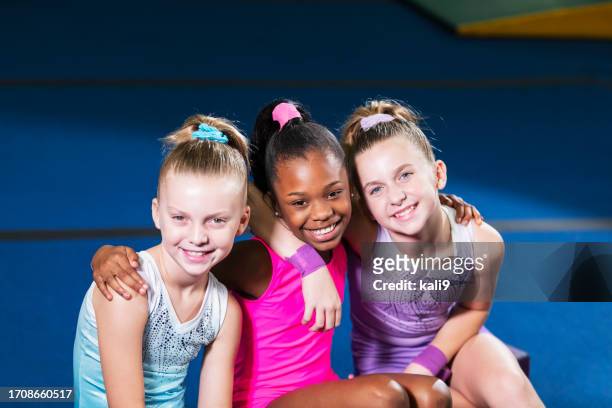 three young gymnasts smiling at camera - kids gymnastics stock pictures, royalty-free photos & images