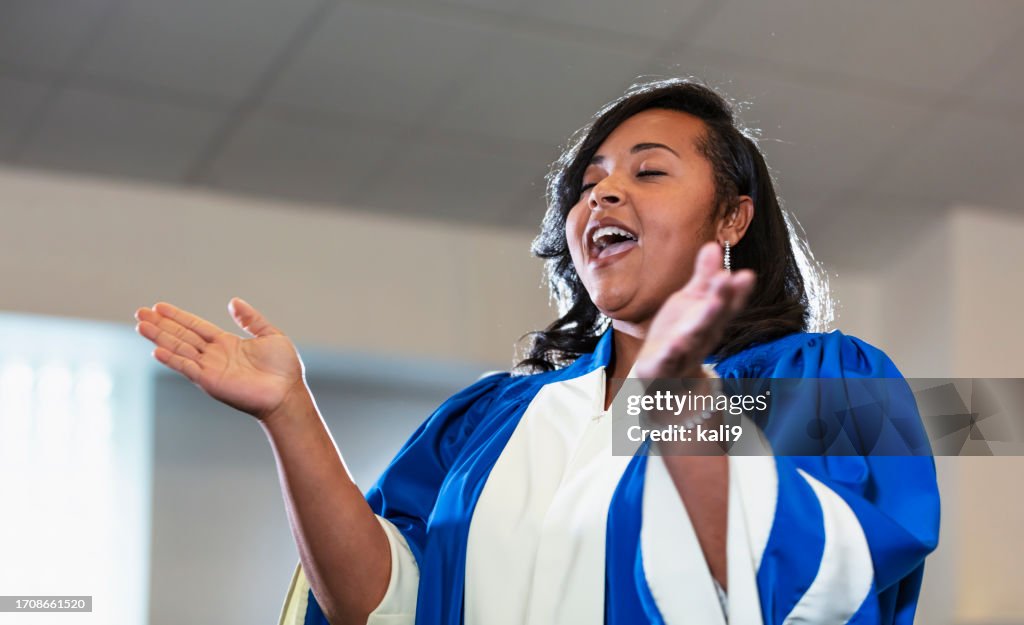 Mulher negra adulta cantando no coral da igreja