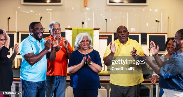 black men and women standing, clapping and singing - southern church stock pictures, royalty-free photos & images