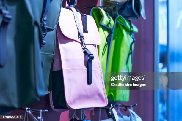 group of women's bags hanging on the shelf in a store with no people around, front view - lila handtasche stock-fotos und bilder