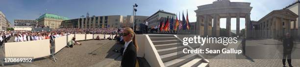 In this 180 degree panorama photo people sitting under a blistering sun on Pariser Platz square listen to U.S. President Barack Obama speak at the...