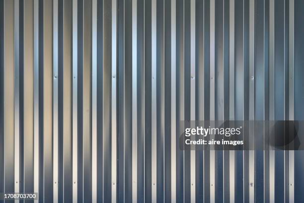 texture of a zinc sheeting corugated steel cladding in the foreground for a wall, front view - steel stock pictures, royalty-free photos & images