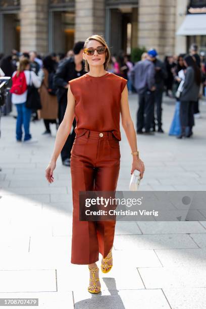 Olivia Palermo wears rust brown sleeveless shirt, pants, yellow heels, sunglasses outside Giambattista Valli during the Womenswear Spring/Summer 2024...