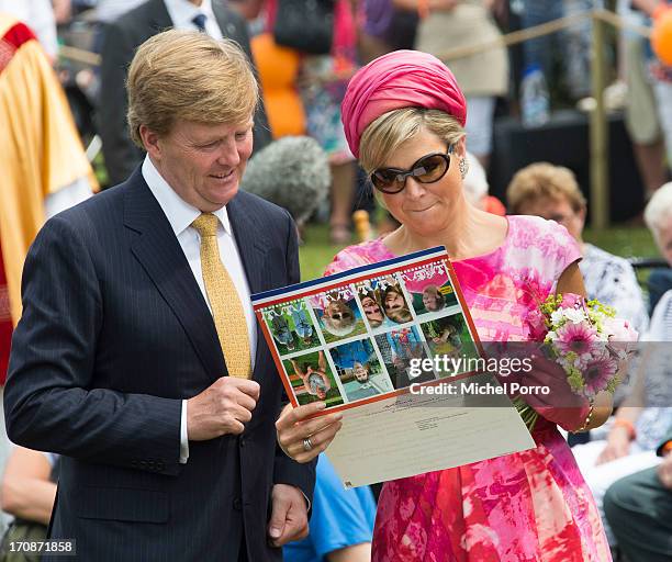 King Willem-Alexander of The Netherlands and Queen Maxima of The Netherlands receive a postcard during an official visit to the town centre on June...