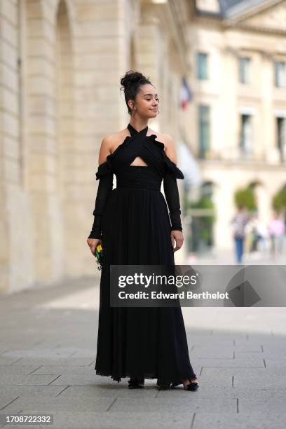 Lena Mahfouf aka Lena Situations wears a black gathered off-shoulder long dress with cutouts, outside Giambattista Valli, during the Womenswear...