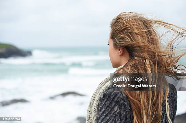 woman looking out to sea. - long hair wind stock pictures, royalty-free photos & images