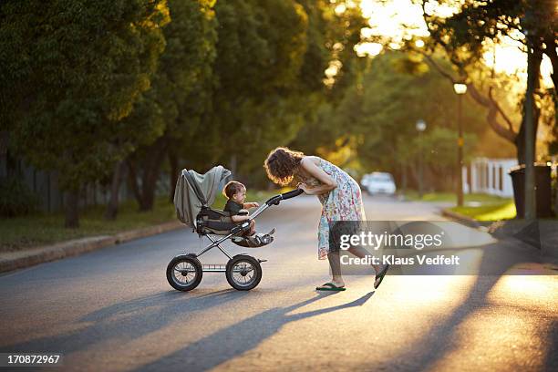 mother & son walking with stroller in the sunset - the stroller stock pictures, royalty-free photos & images