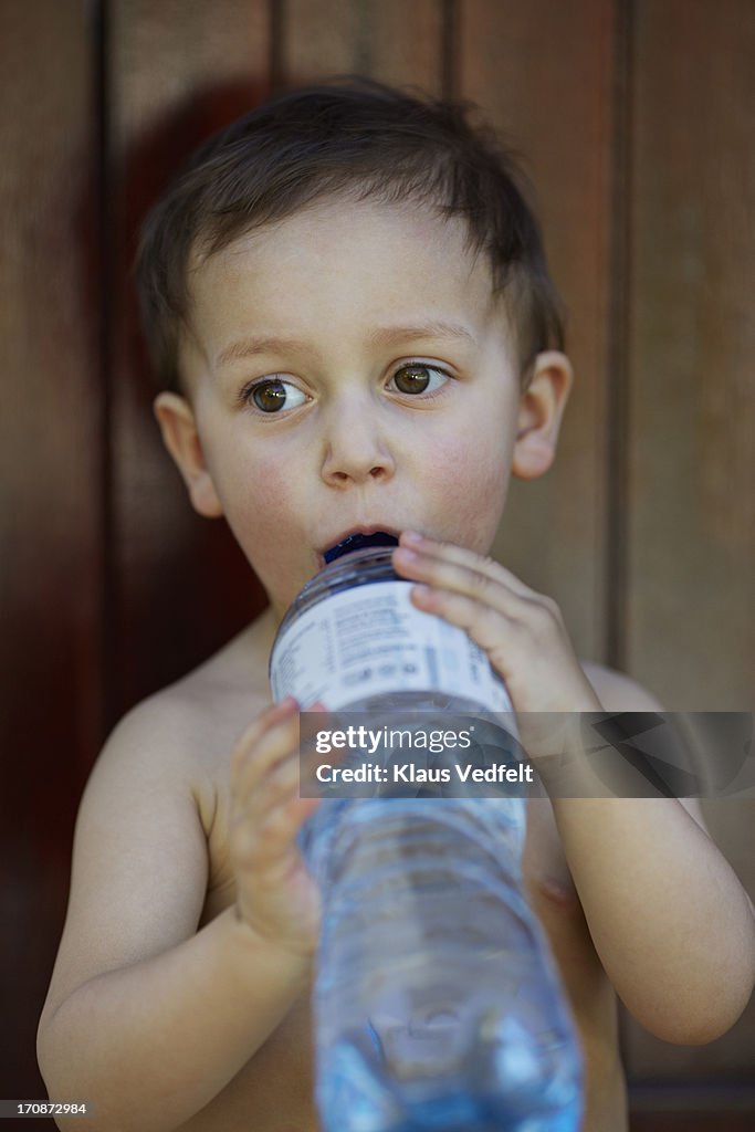 Cute boy drinking from water bottle