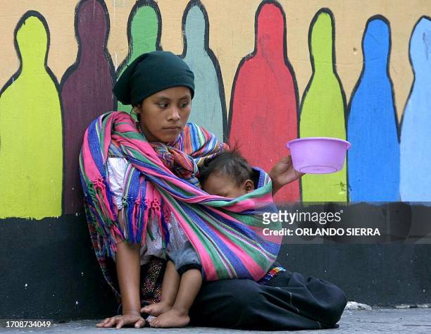 Una joven indigena y su pequeno hijo piden limosna el 31 de agosto de 2003 en el centro historico de ciudad de Guatemala. El 40% de los pueblos...