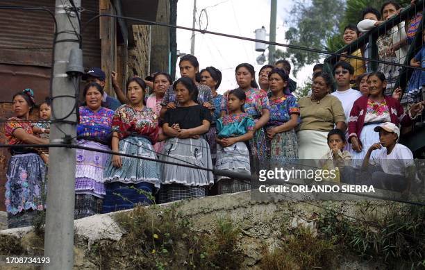 Civilians observe thousands of Guatemalan teachers march, 28 February 2003, in Guatemala City. Teachers are in the fifth week of strikes demanding...