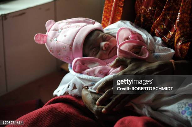 New born baby girl Nargis sleeps in her mother Vinita arms hours after she delivered the baby at a Community Health Center in Mall, near the central...