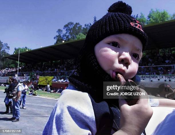 Child dressed as Subcomandante Marcos waits as the Zapatista caravan approaches 10 March 2001. Un nino vestido como el sub comandante Marcos, el sub...