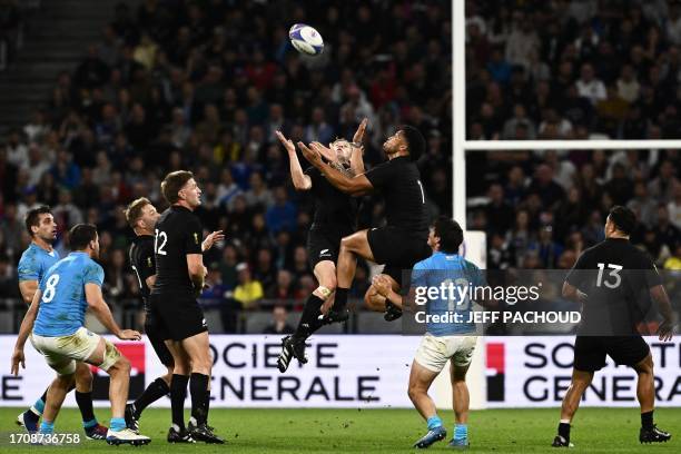 New Zealand's full-back Damian McKenzie and New Zealand's left wing Leicester Fainga'anuku jump to catch the ball during the France 2023 Rugby World...