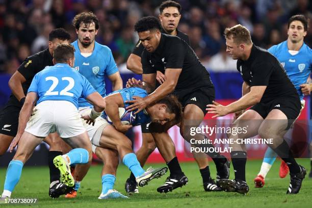 Uruguay's left wing Nicolas Freitas is tackled by New Zealand's left wing Leicester Fainga'anuku during the France 2023 Rugby World Cup Pool A match...