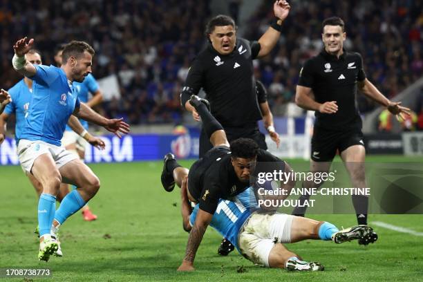 New Zealand's left wing Leicester Fainga'anuku is tackled by Uruguay's left wing Nicolas Freitas during the France 2023 Rugby World Cup Pool A match...