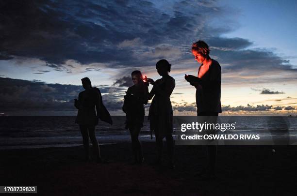 Tourists take pictures of olive ridley turtles during nesting season at La Flor Wildlife Refugee in San Juan del Sur, Nicaragua on October 5, 2023....