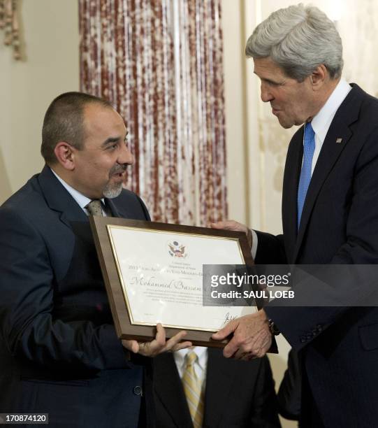 Secretary of State John Kerry presents Mohammed Bassam Al-Nasseri of Iraq with a Trafficking in Persons Heroes' award during an event releasing the...