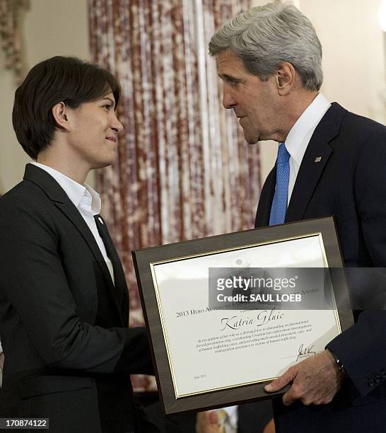 Secretary of State John Kerry presents Katrin Gluic of Croatia with a Trafficking in Persons Heroes' award during an event releasing the Annual...