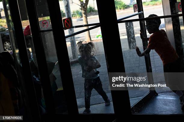 Migrant kids living at the Chicago Police Department's 15th District play in a revolving door on Sunday, September 10, 2023 in Chicago, Illinois....