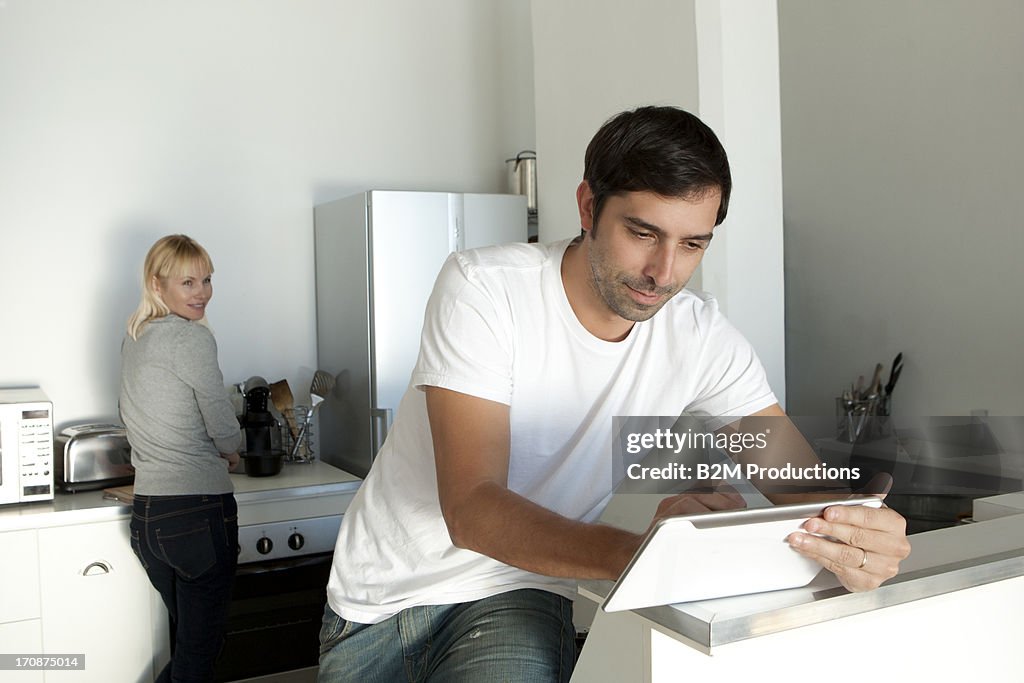 Man looking at digital tablet in kitchen