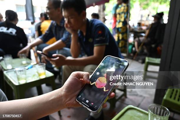 Man looks at the social media platform TikTok on his mobile phone in Hanoi on October 6, 2023. Social media platforms operating in Vietnam including...