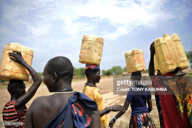 South Sudanese women carry jerry-cans filled with water on their heads on April 2 at Terekeka, 82 km north of Juba, an area where the population is...