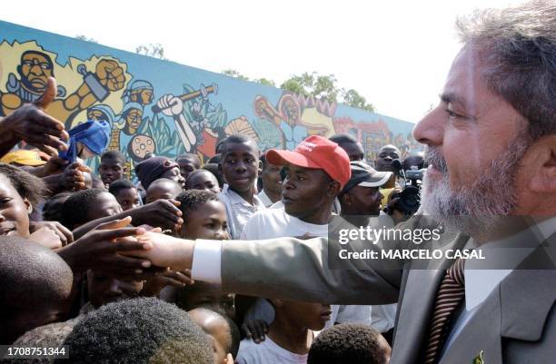 Brazilian President Luiz Inacio Lula da Silva waves children, 05 November 2003, after paying homage to the National Heroes in Maputo, during a...