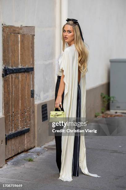 Emili Sindlev wears black white pants, creme white top with feathers, Hermes bag outside Victoria Beckham during the Womenswear Spring/Summer 2024 as...