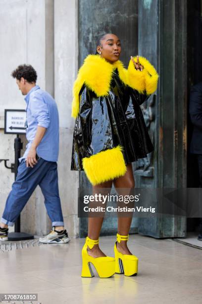Crazy Sally wears black yellow vinyl coat outside Nina Ricci during the Womenswear Spring/Summer 2024 as part of Paris Fashion Week on September 29,...