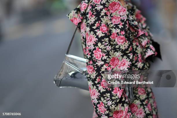 Heart Evangelista wears a cross necklace, a low neck mini dress with floral print, a silver bag, outside Alessandra Rich, during the Womenswear...