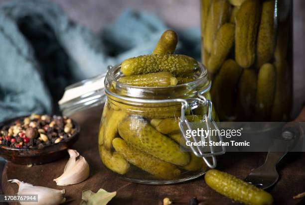 green pickle cucumbers in a glass jar - augurk stockfoto's en -beelden