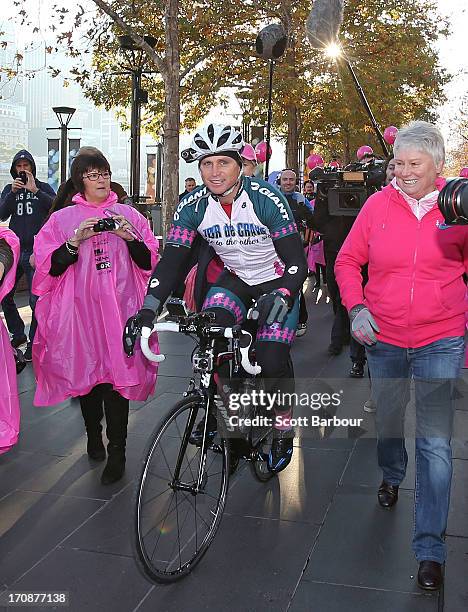 Shane Crawford is followed by Raelene Boyle as he starts cycling as he begins the Shane Crawford Charity Bike Ride at Crown Riverwalk on June 20,...