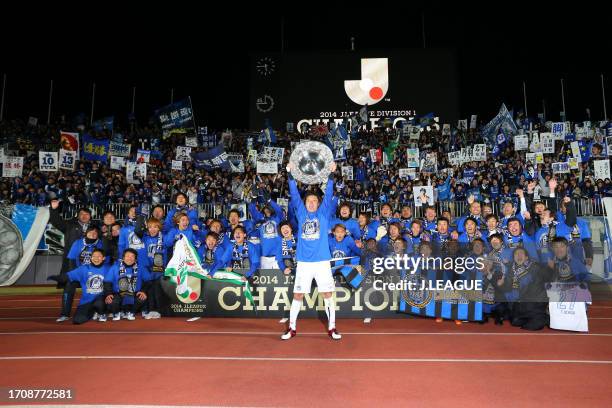 Captain Yasuhito Endo of Gamba Osaka lifts the J.League Champions plaque in front of fans as the team celebrates the J.League J1 season champions...