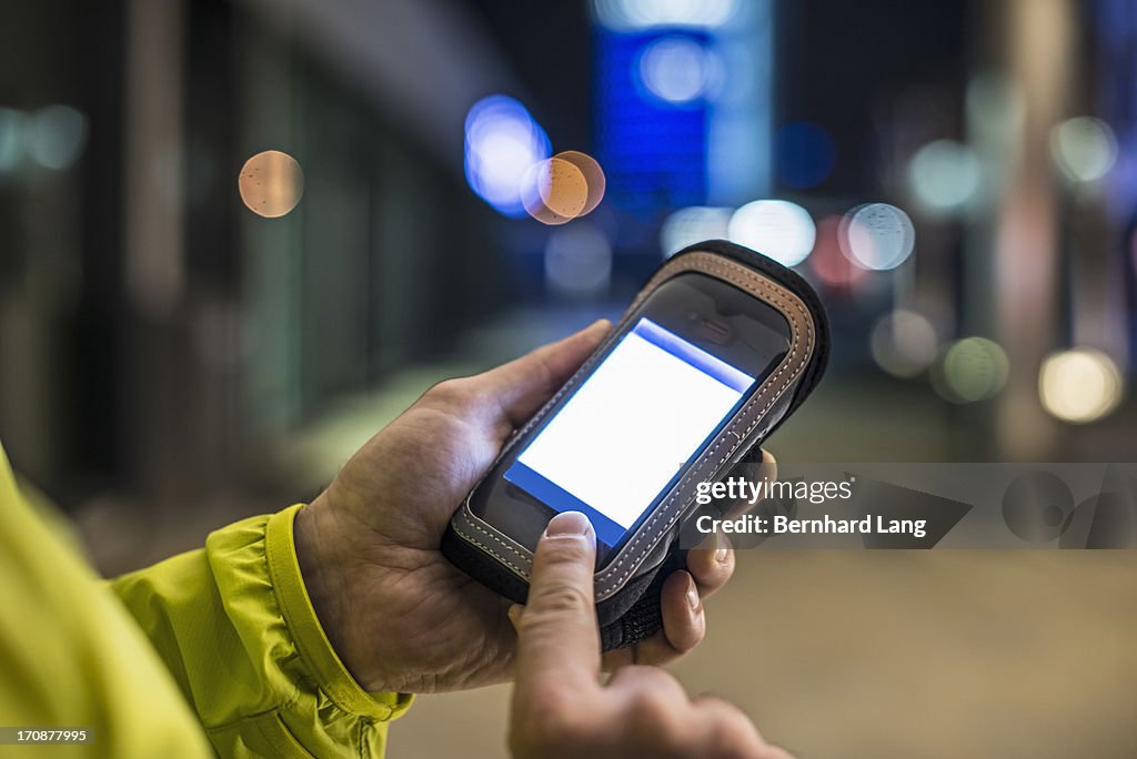 Runner touching protected smartphone in city