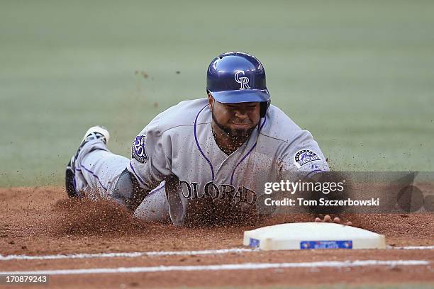 Wilin Rosario of the Colorado Rockies dives back to first base to avoid being doubled off in the third inning during MLB game action against the...