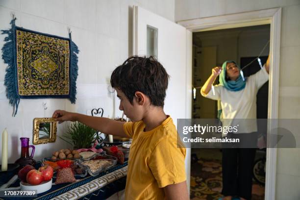 mother and son decorating home for nowruz holiday - kurdish new year stock pictures, royalty-free photos & images