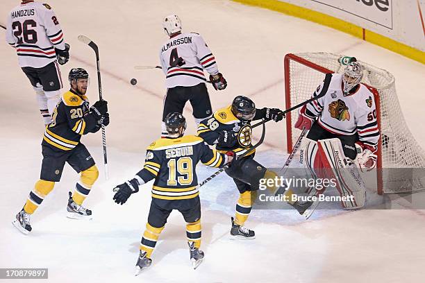 Rich Peverley of the Boston Bruins celebrates with teammates Daniel Paille and Tyler Seguin after scoring a goal against Corey Crawford of the...