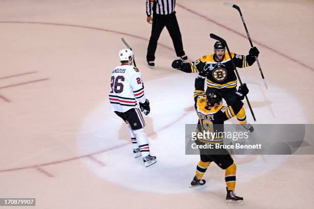 Rich Peverley of the Boston Bruins celebrates with Daniel Paille after scoring a goal as Michal Handzus of the Chicago Blackhawks looks on during the...