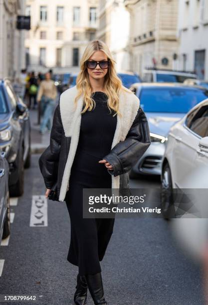 Nadine Leopold wears black white shearling jacket, dress, over knees boots, bag outside Victoria Beckham during the Womenswear Spring/Summer 2024 as...