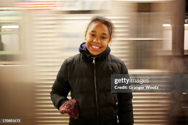 mixed race girl smiling in subway station - new york city subway stock-fotos und bilder