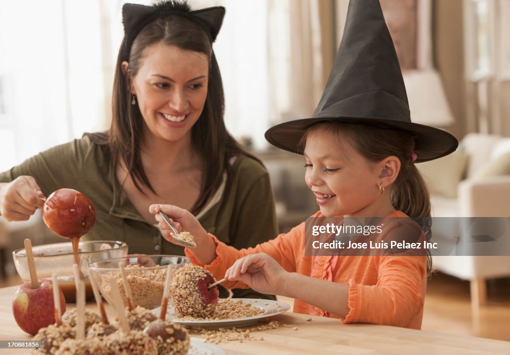 Caucasian mother and daughter making caramel apples