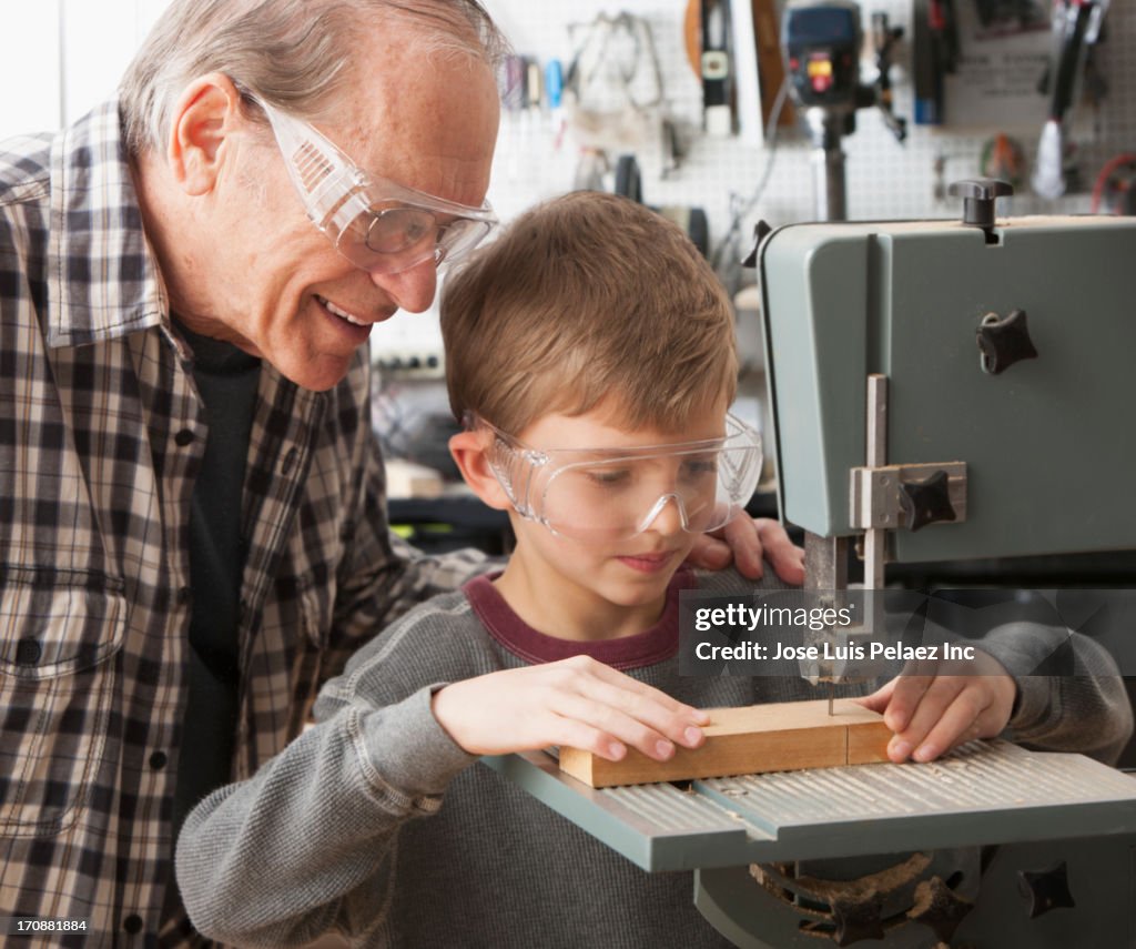 Caucasian man and grandson working in woodshop