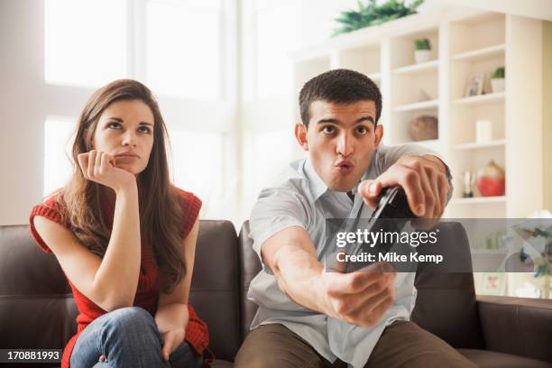 woman watching boyfriend play video games - lehi stock-fotos und bilder